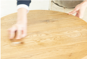 テーブルをサンドペーパーで削る写真