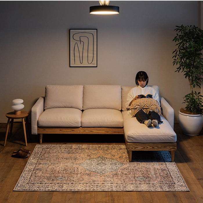 ソファでくつろいで読書をする女性とグローLEDライト