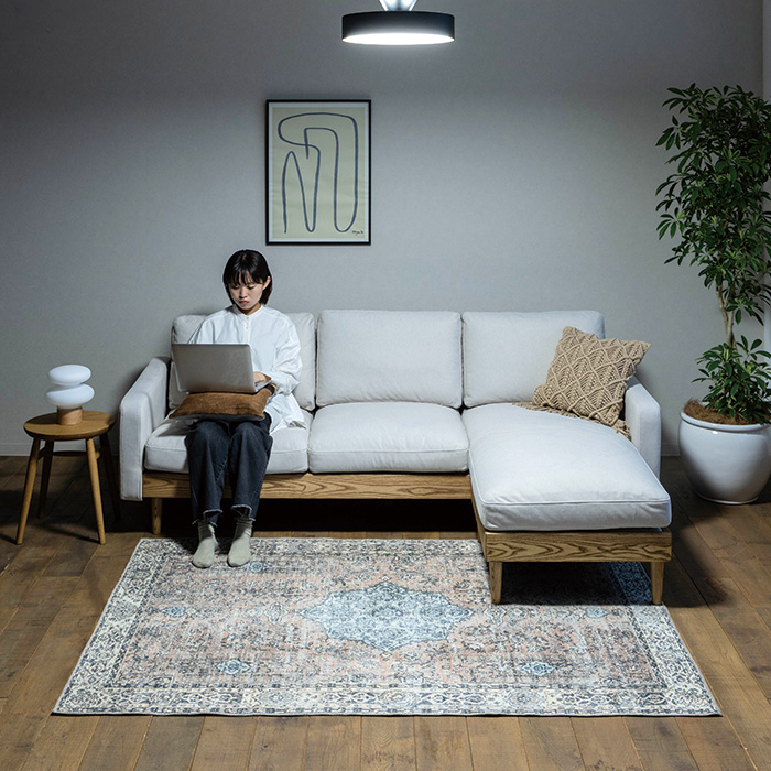 ソファに座ってPC仕事をする女性とグローLEDライト