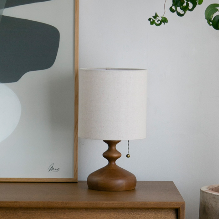 カーブを描くウッドベースと、優しい光を灯すファブリックシェードのトーヴェ テーブルランプ（ライト）消灯時
