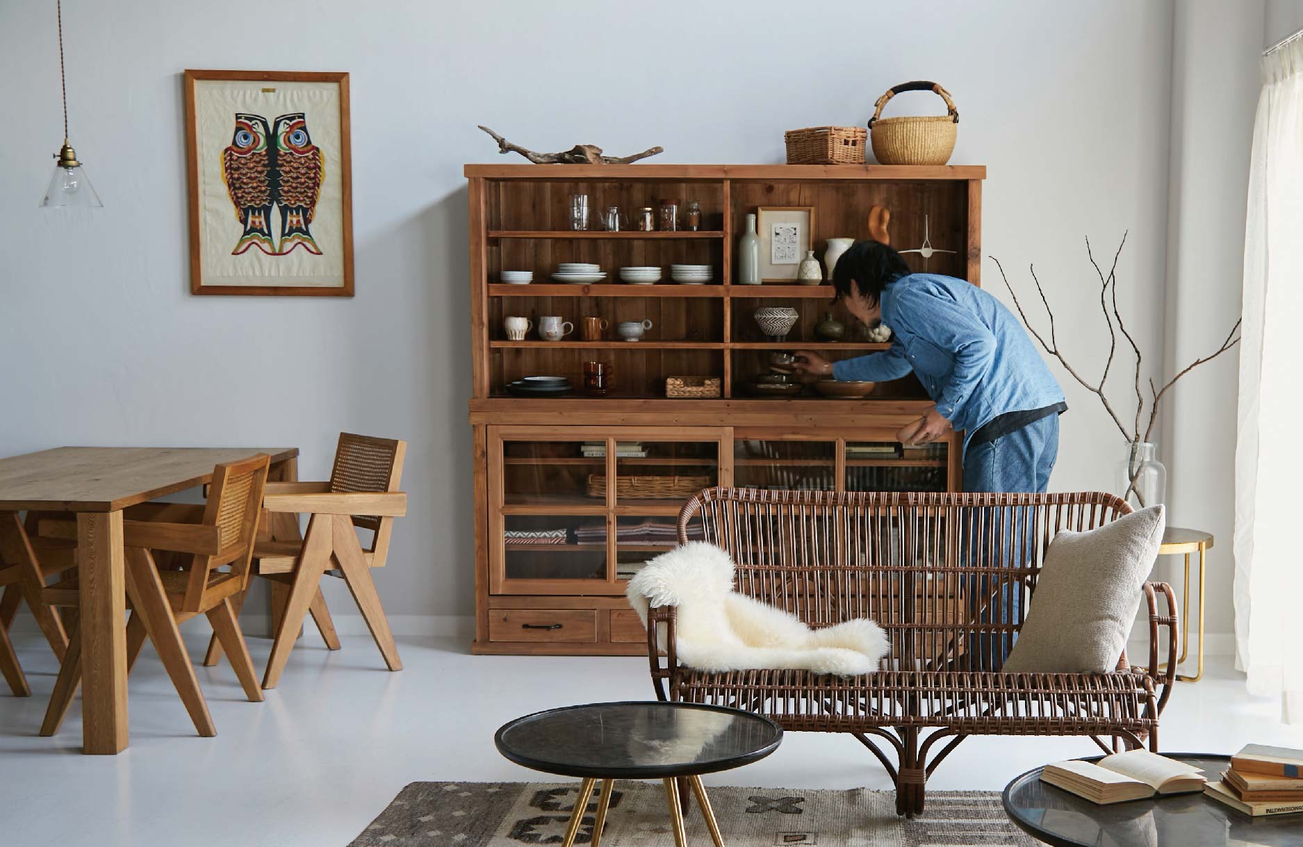 大型収納家具からコレクションを取り出す男性の写真